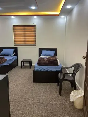 a room with two beds and a chair in it at Rum Awaad luxury camp in Wadi Rum