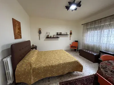 a bedroom with a bed and a chair and a window at Alice & Andrew Apt. Few Steps to Madaba Old City Center in Madaba