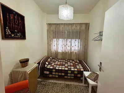 a bedroom with a bed and a window at Alice & Andrew Apt. Few Steps to Madaba Old City Center in Madaba