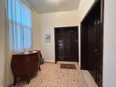 a hallway with a black door and a window at Alice & Andrew Apt. Few Steps to Madaba Old City Center in Madaba