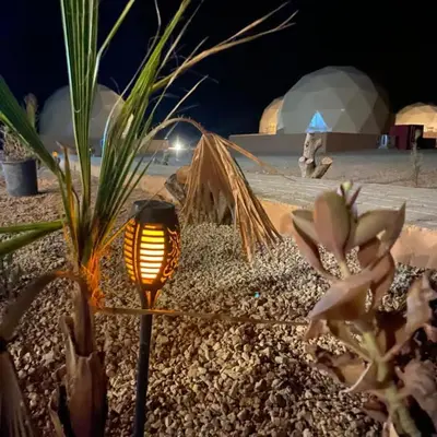 a light in the middle of a desert at night at Wadi Rum Aviva camp in Wadi Rum