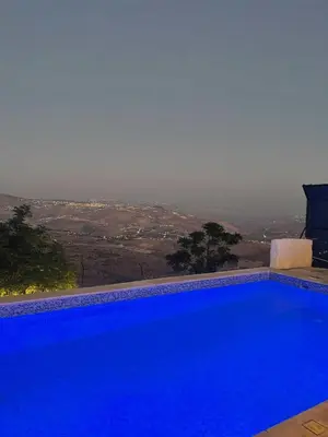 a large blue swimming pool with a view at Lionden jerash استراحة وشالي عرين الاسد جرش in Jerash
