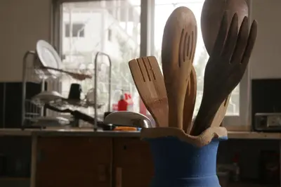 a blue vase filled with wooden utensils in a kitchen at St.Jadoor Inn in Al Azraq ash Shamālī