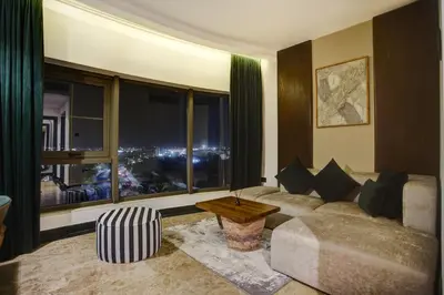 a living room with a couch and a large window at Bratus Hotel in Aqaba