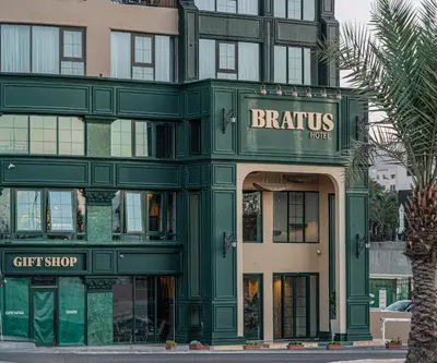 a green building with a gift shop in front of it at Bratus Hotel in Aqaba