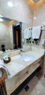 a bathroom with a sink and a large mirror at Petra Moon Luxury Hotel in Wadi Musa
