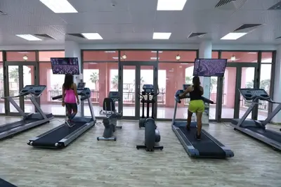 two women exercising on tread machines in a gym at Maria Beach Ground Floor Apartament in Aqaba