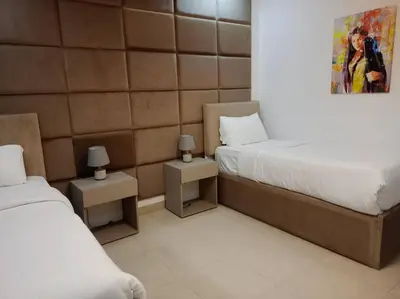 a bedroom with two beds and a painting on the wall at Maria Beach Ground Floor Apartament in Aqaba