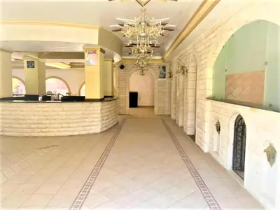 a hallway in a building with a chandelier at Nojoom Hotel in Amman