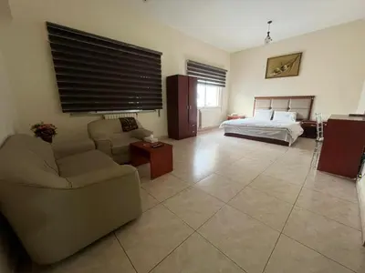 a living room with a couch and a bed at Nojoom Hotel in Amman