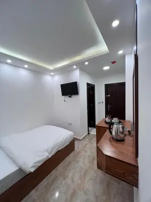 a bedroom with a bed and a table and a tv at Petra Family Hotel in Wadi Musa