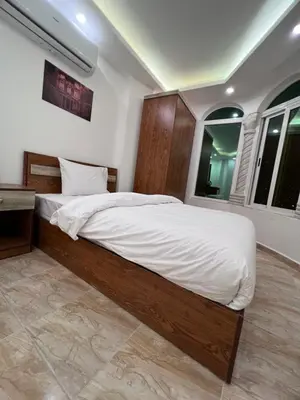 a bedroom with a large bed with white sheets at Petra Family Hotel in Wadi Musa