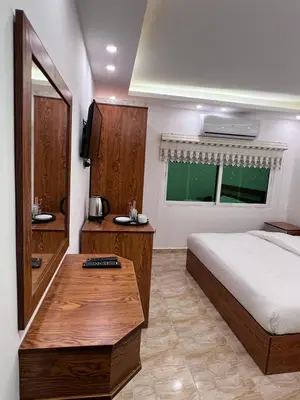 a bedroom with a bed and a wooden table at Petra Family Hotel in Wadi Musa