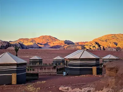 a group of tents in the middle of a desert at The Villas - Bedouin Boutique Resort in Wadi Rum