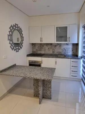 a kitchen with white cabinets and a granite counter top at Byblos Prime in Aqaba