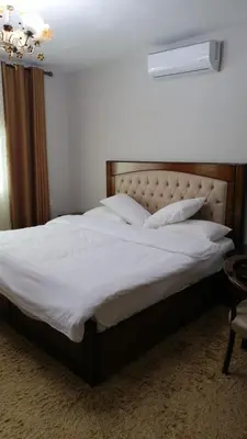 a bedroom with a large bed with white sheets and pillows at Cozy House in Wadi Musa