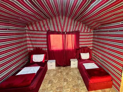 a room with two beds and a striped wall at Dana Sunset Eco Camp in Dana