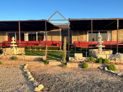 a building with red benches in front of it at Dana Sunset Eco Camp in Dana