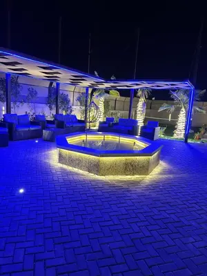 a patio with a pool at night with blue lighting at The royal cottage Amman in Al Qasţal