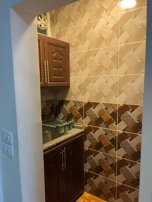 a kitchen with a sink and a tiled wall at Petra Main Gate Studios in Wadi Musa
