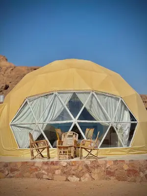 a dome tent with chairs and tables in it at Nara Wadi RUM Camp in Wadi Rum