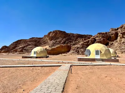 two domes in the middle of a desert at Nara Wadi RUM Camp in Wadi Rum