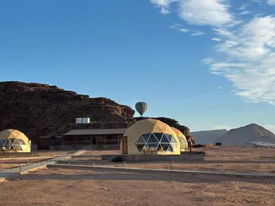 a building in the middle of a field at Nara Wadi RUM Camp in Wadi Rum