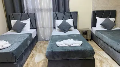 a room with two beds with towels on them at Petra Rose Apartment in Wadi Musa