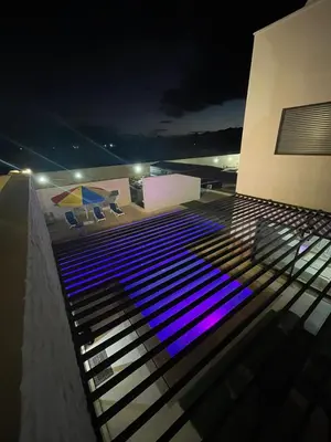 a building with blue lights on the roof at night at مزرعة وفيلا الريان وادي رم in Ruʼaysat al Khālidī