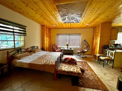 a bedroom with a large bed with a wooden ceiling at Oak Farm مزرعة الملّول in Ajloun