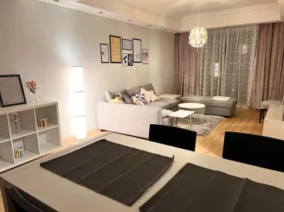 a living room with a couch and a table with chairs at Ronza Elegant Apartment in Amman
