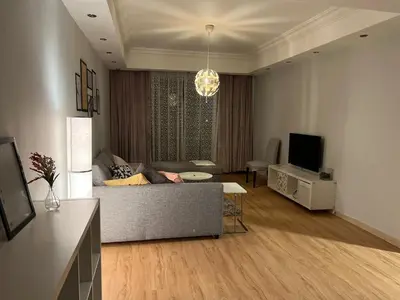 a living room with a couch and a television at Ronza Elegant Apartment in Amman