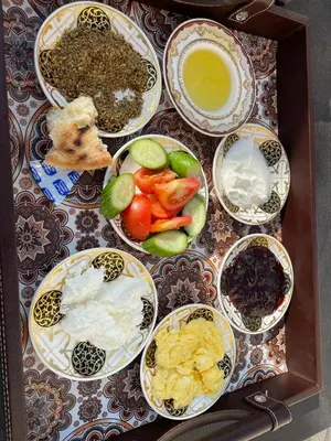 a table topped with bowls of different types of food at Petra Inn House in Wadi Musa