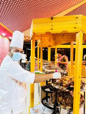 a chef is preparing food on a table at Wadi Rum Alia Luxury Camp in Wadi Rum