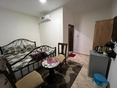 a bedroom with a bed and a table and a couch at Horizon22 in Wadi Musa