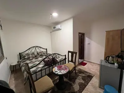 a bedroom with a bed and a table and a chair at Horizon22 in Wadi Musa