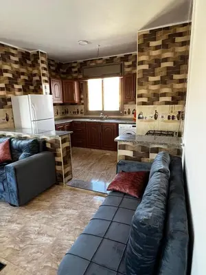 a living room with a couch and a kitchen at Horizon22 in Wadi Musa