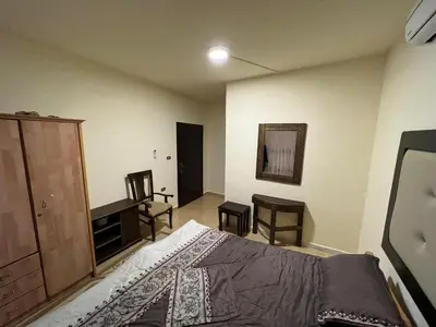 a bedroom with a bed and a dresser and a desk at Horizon22 in Wadi Musa