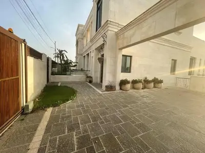 a large white building with potted plants in a courtyard at Contemporary Semi Villa Apartment with Private Entrance in Khalda in Amman