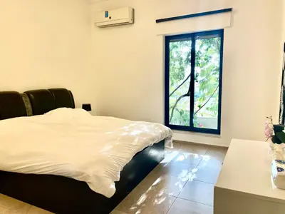 a bedroom with a bed and a window at Contemporary Semi Villa Apartment with Private Entrance in Khalda in Amman