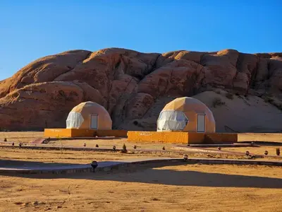 two domes in the desert next to a mountain at Anwar Al Qamar Luxury Hotel in Wadi Rum