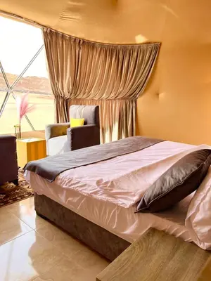 a bedroom with a large bed and a window at Anwar Al Qamar Luxury Hotel in Wadi Rum