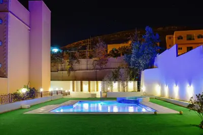 a swimming pool in the yard of a building at night at Petra Castle Hotel in Wadi Musa