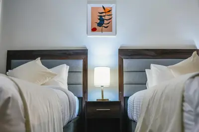 a bedroom with two beds and a lamp on a night stand at Petra Castle Hotel in Wadi Musa