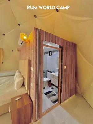 a room with a bed and a mirror in a tent at RUM WORLD BUBBLE lUXURY CAMP in Wadi Rum