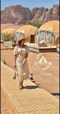 a woman walking down a path in the desert at RUM WORLD BUBBLE lUXURY CAMP in Wadi Rum