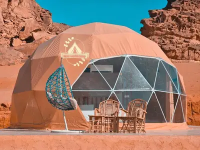 a dome tent with chairs in the desert at RUM WORLD BUBBLE lUXURY CAMP in Wadi Rum