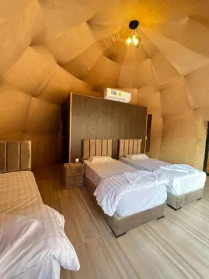 two beds in a room with a wooden ceiling at Wadi rum desert sky in Wadi Rum