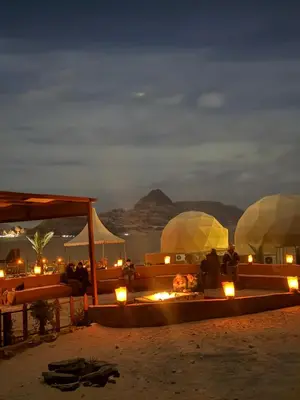 a group of people sitting on a beach at night at Rum Royal Dunes Camp & tour in Wadi Rum