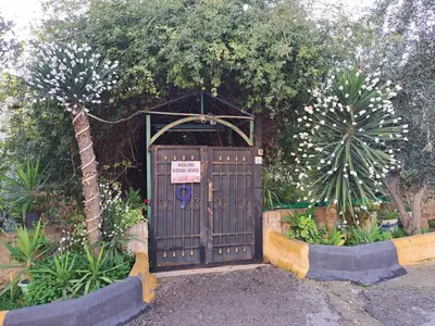 a wooden door with a sign on it in a garden at بيت الطبيعة nature house in Jerash